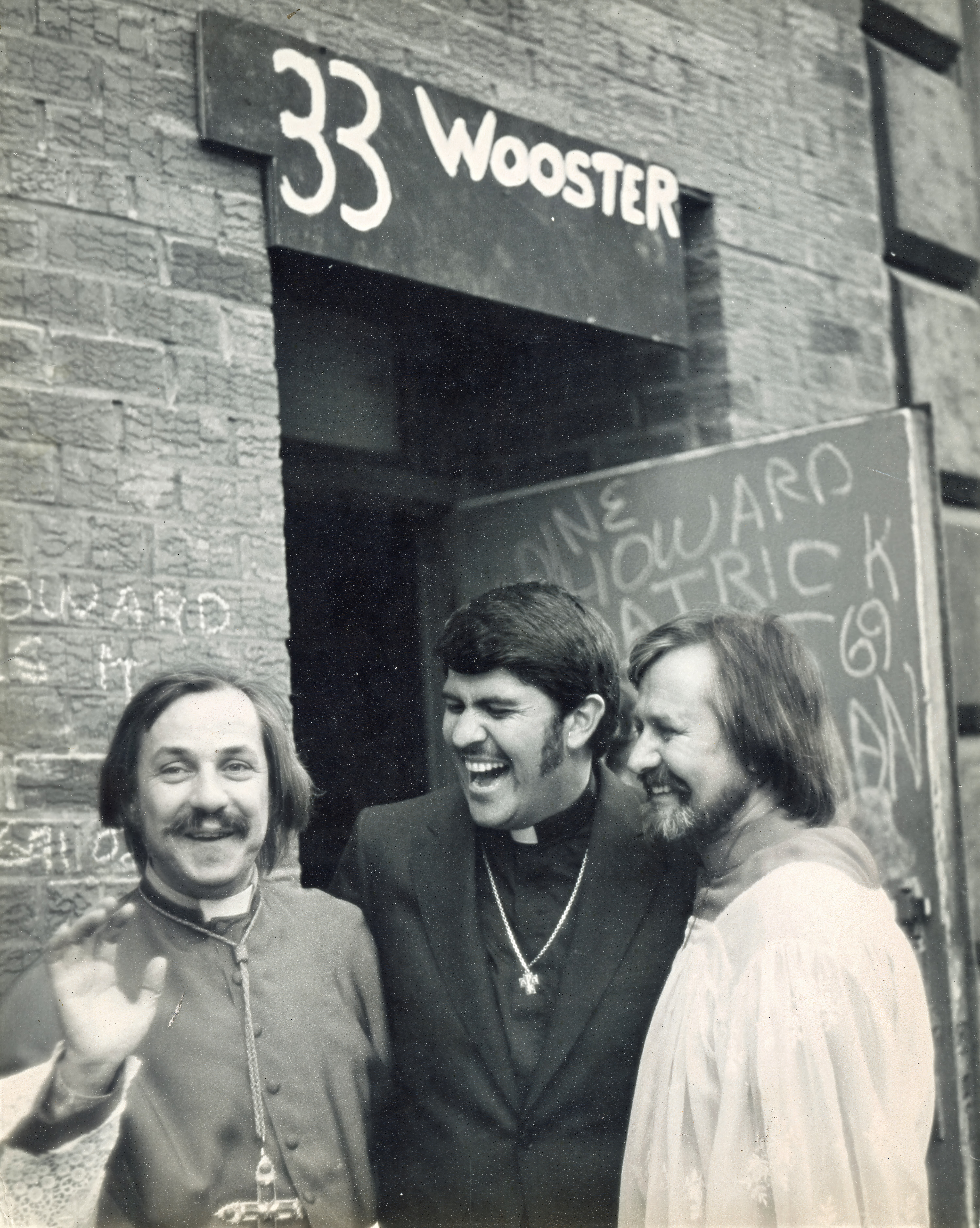 Pastor Troy Perry, Father Robert Mary Clement, and John Darcy Noble outside the Performing Garage following the Holy Union ceremony. Standing beneath the entrance to 33 Wooster Street in Manhattan's SoHo neighborhood, Troy Perry (center), founder of the Metropolitan Community Church, celebrates with Robert Mary Clement (left) and John Darcy Noble (right) after officiating their Holy Union. Although the Metropolitan Community Church and the Church of the Beloved Disciple were sometimes viewed as competing ministries within the emerging LGBTQ Christian movement, Perry and Clement maintained a warm personal friendship and shared a commitment to providing spiritual community for lesbian and gay Christians during the formative years of the gay liberation movement.