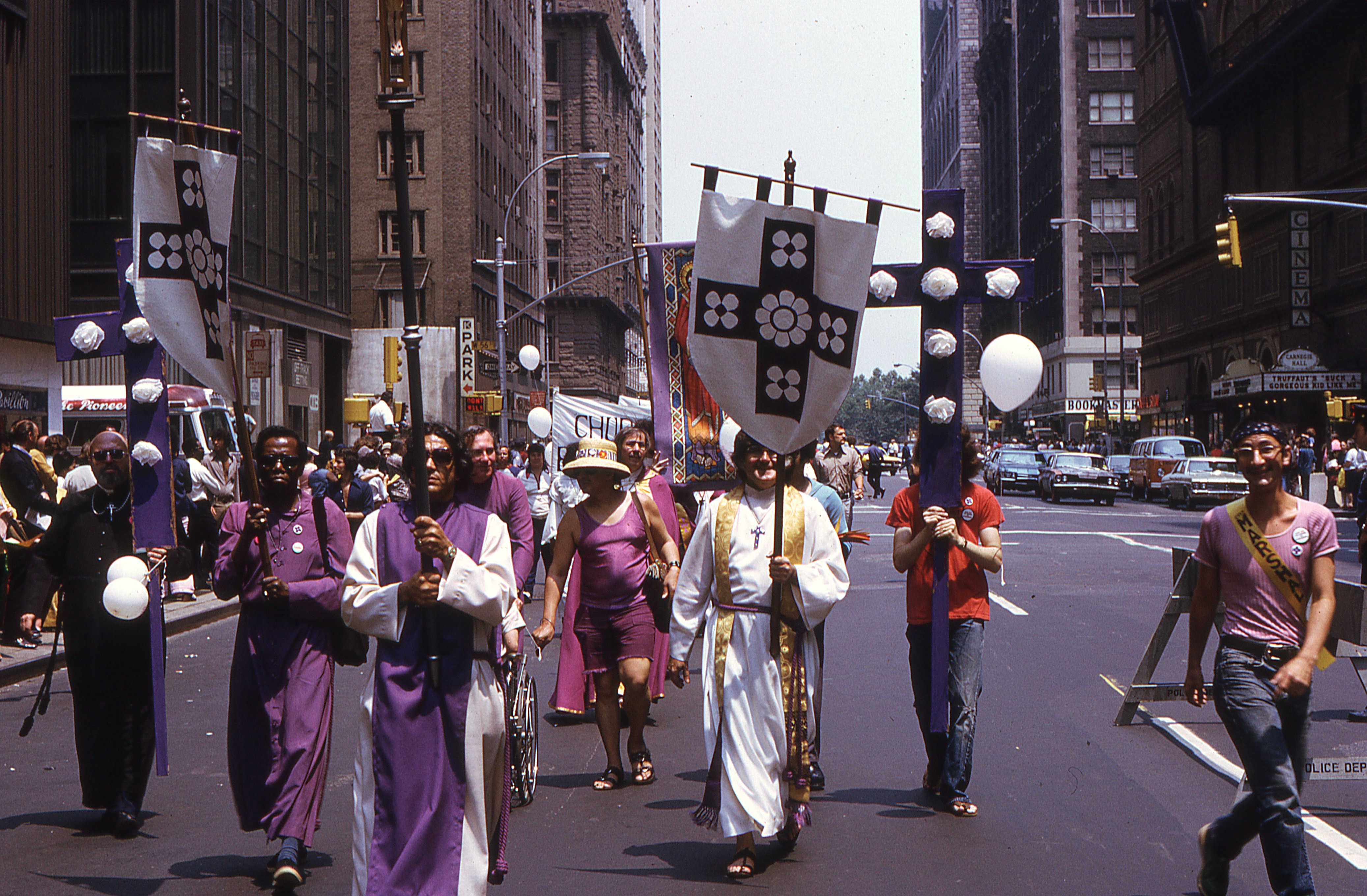 Members of the Church of the Beloved Disciple process through Midtown Manhattan during the Fifth Annual Christopher Street Liberation Day March on June 30, 1974. Marching beneath processional crosses, banners, and the church's heraldic standard, the congregation transformed the annual Pride march into a public act of Christian witness, proclaiming that LGBTQ people belonged fully within the sacramental life of the Church. By 1974, the Church of the Beloved Disciple had become one of the most visible religious organizations participating in New York City's Pride celebrations, bringing liturgy, sacred art, and public faith into the heart of the growing gay liberation movement.