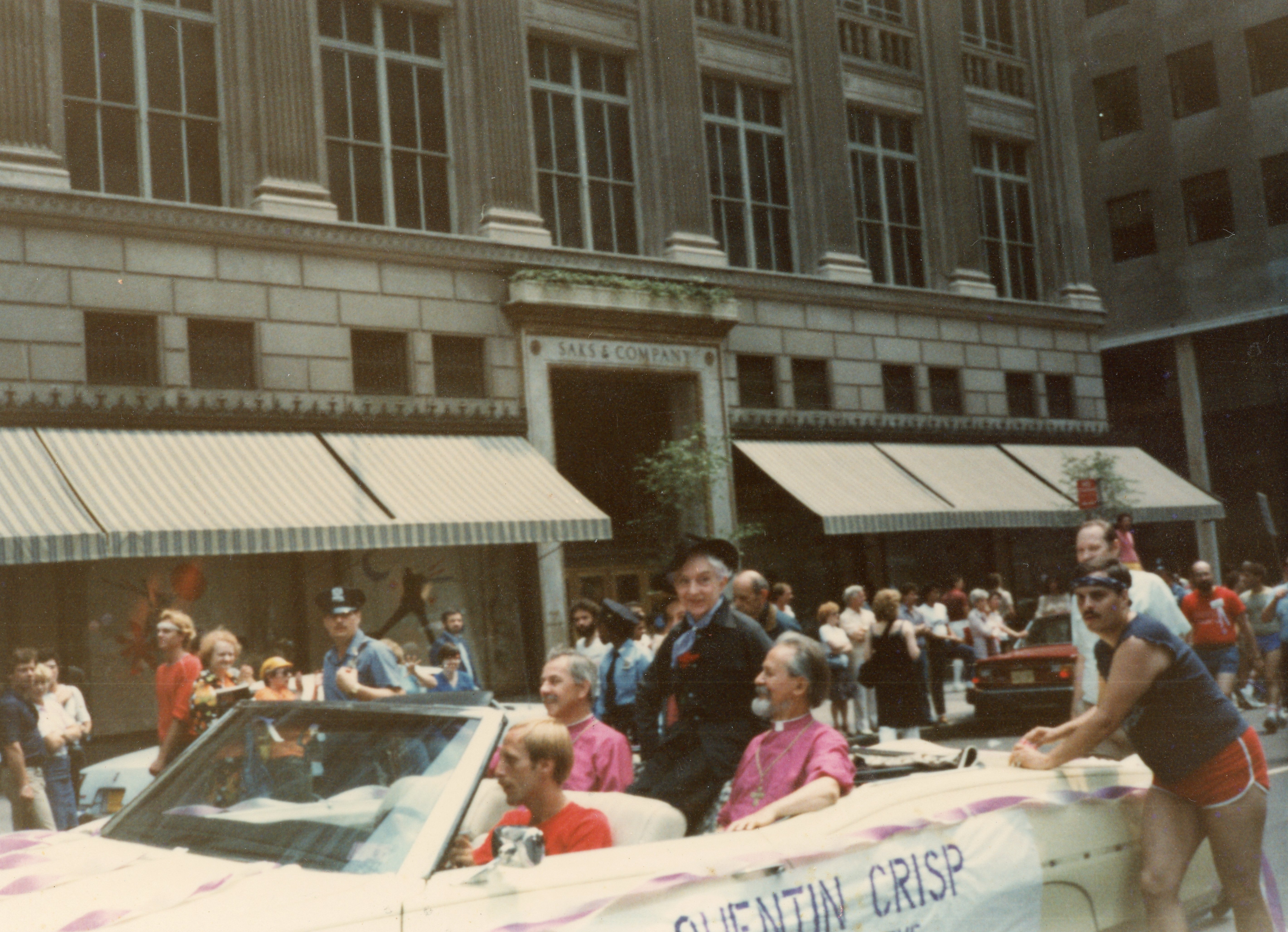 English writer and gay icon Quentin Crisp (center) rides with Bishop John Darcy Noble (left) and Bishop Robert Mary Clement (right) in the Church of the Beloved Disciple's lead convertible during the 13th Annual Gay Pride Day March in New York City on June 27, 1982.