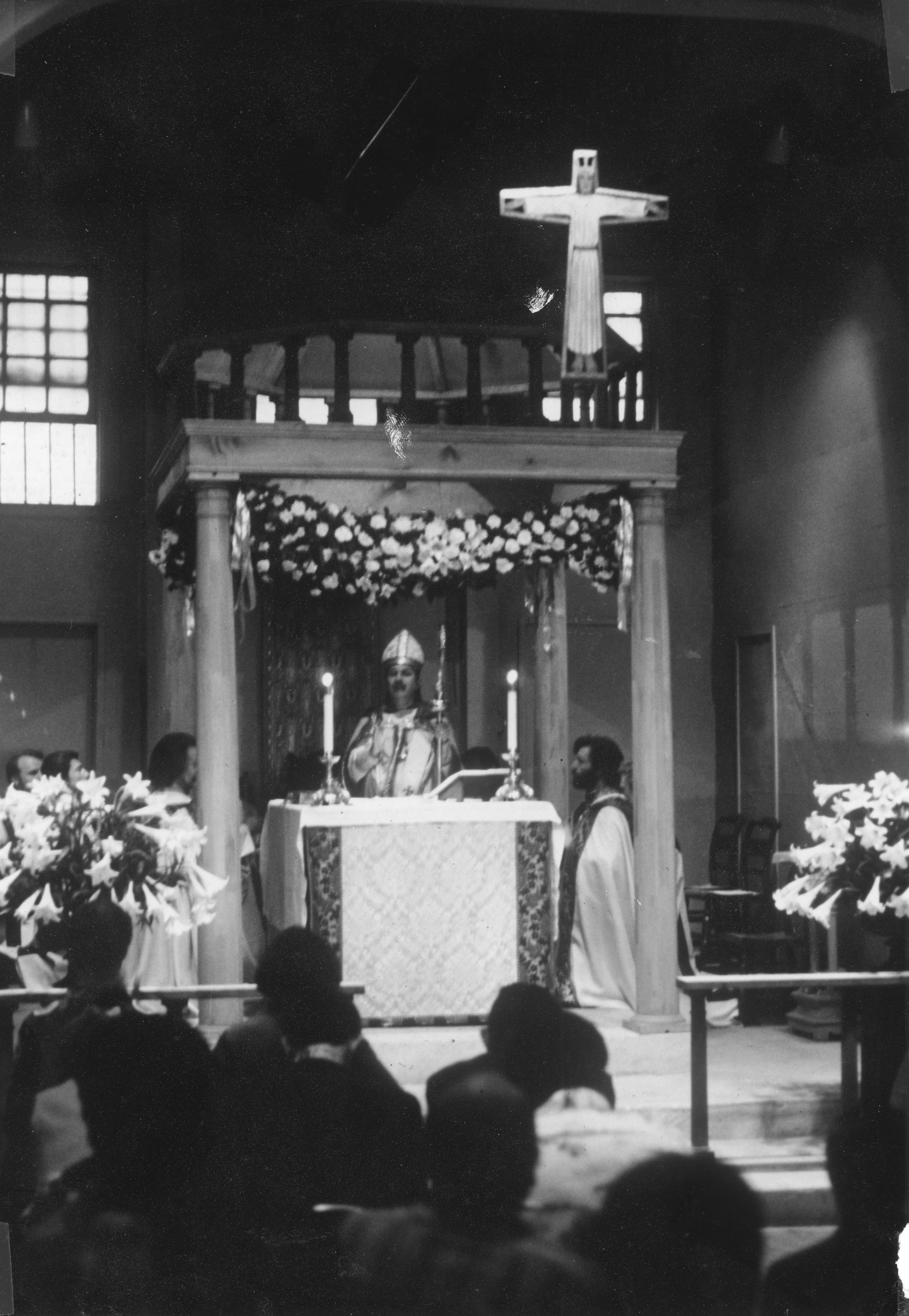 Archbishop Robert M. Clement with Fr. Leo (on his left) and Fr. John (on his right) celebrates the Pontifical Mass of Easter Sunday before a congregation gathered in the Church of the Beloved Disciple's permanent sanctuary. Surrounded by clergy and elaborate Easter floral decorations, the solemn liturgy exemplified the church's commitment to the full ceremonial tradition of Catholic worship while serving an openly LGBTQ-affirming community. The Mass takes place at 348 West 14th Street.