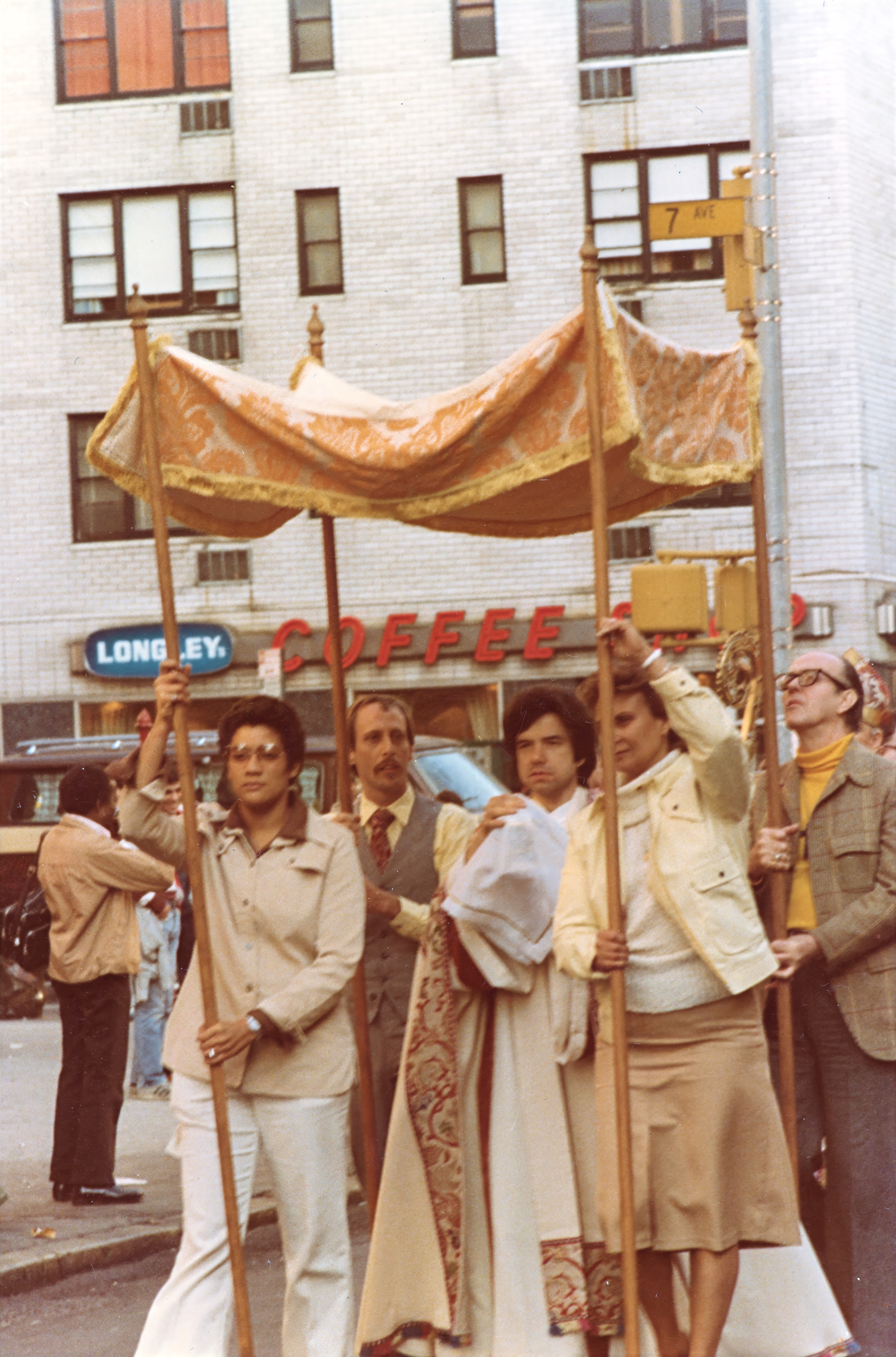 Members of the Church of the Beloved Disciple carry a ceremonial canopy during a Corpus Christi procession through the streets of Manhattan. Beneath the canopy, clergy bore the Blessed Sacrament in a public witness to the Real Presence of Christ, continuing a centuries-old Catholic tradition in the heart of New York's gay community. For the congregation, such processions united sacramental devotion with public visibility, proclaiming that LGBTQ Christians belonged fully within the life and worship of the Church.