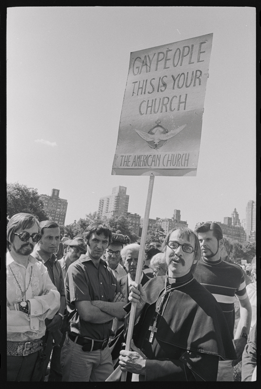 Photograph of Robert Mary Clement in the first Christopher Street Liberation Day Parade holding a sign "Gay People this is Your Church"